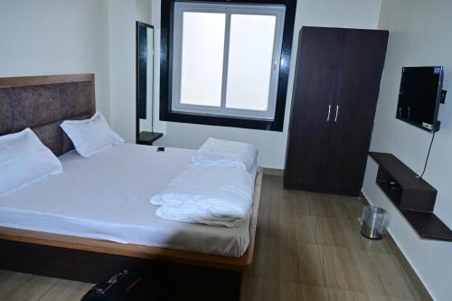 Dormitorio pequeño con cama y ventana en HOTEL MAYUR, en Pratāpgarh