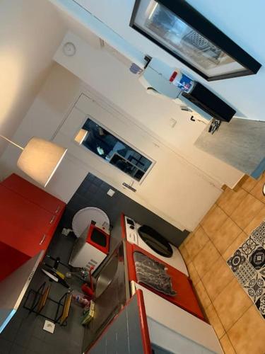 - une vue sur la cuisine dotée de placards rouges dans l'établissement Studio coquet, à Morangis