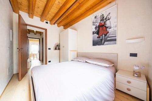 a bedroom with a white bed and a painting on the wall at Residence Porta Della Muda in Vittorio Veneto
