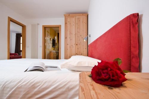 a bedroom with a bed with a red rose on it at Hotel Martinelli in Ronzo Chienis