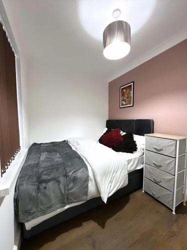 a bedroom with a bed and a dresser in it at Md Stays in London