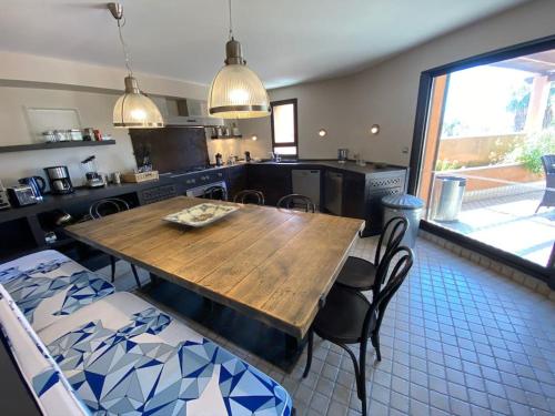 une cuisine avec une table en bois et quelques chaises dans l'établissement Chambre Emeraude, Riad 9 Couple only au village naturiste, au Cap d'Agde