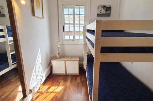 1 dormitorio con 2 literas y escalera en Preciosa casa adosada, en Castelldefels