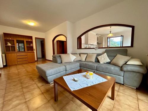 een woonkamer met een bank en een tafel bij Kibilù - Laveno Lago Maggiore ampio trilocale con balcone e posteggio in Laveno