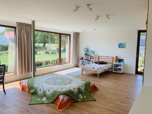 a bedroom with a bed and a large window at Sweet Valley View - Architectenwoning in Zutendaal
