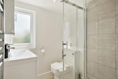 a bathroom with a shower and a toilet and a sink at 2 Bed Duplex Apartment in Wimbledon in London