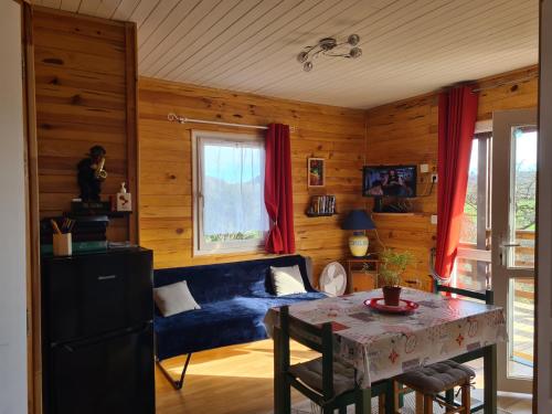 sala de estar con sofá azul y mesa en Chalet au coeur du parc du Morvan - Moux-en-Morvan, en Moux-en-Morvan