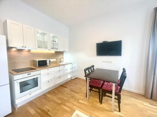 een keuken met een eettafel en een magnetron bij Luxury Central Apartment Easy Kaunas in Kaunas