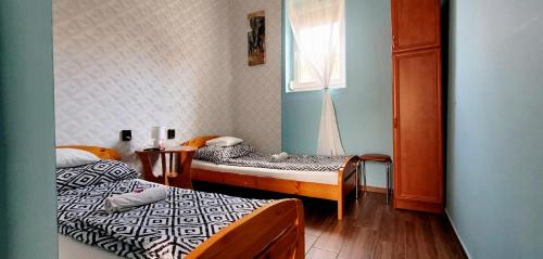 a room with two beds and a window at Megyeház Apartman in Makó