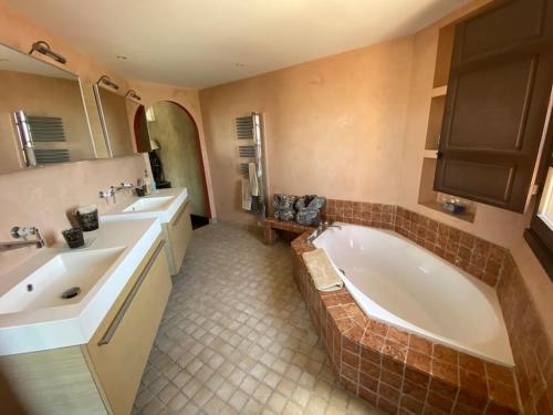 La salle de bains est pourvue d'une baignoire, de 2 lavabos et d'une grande baignoire. dans l'établissement Chambre Ebene, Riad 9 Couple only au village naturiste, au Cap d'Agde