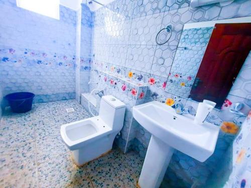 a bathroom with a white toilet and a sink at 1 bedroom with 2 beds, Mombasa Kisimani, Nyali in Mombasa