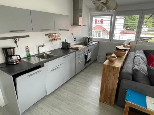 a kitchen with white cabinets and a gray couch at Amt11 - Relax / family / home-office in Bad Wörishofen