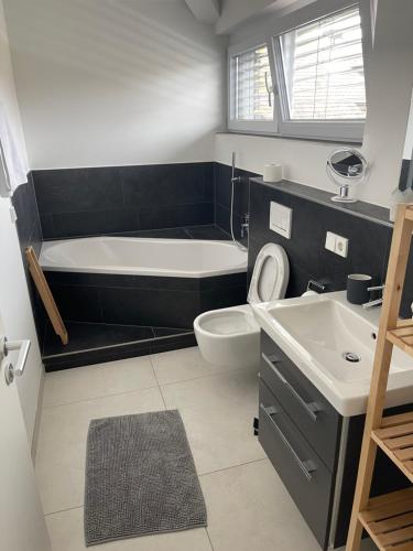 ein Badezimmer mit einer Badewanne, einem WC und einem Waschbecken in der Unterkunft Amt11 - Relax / family / home-office in Bad Wörishofen
