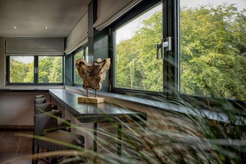 a room with windows and a sculpture on a counter at Hotel Gastronomique de Echoput in Apeldoorn