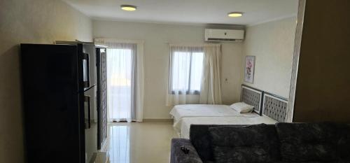 een slaapkamer met een bed, een bank en ramen bij New house in Sharm El Sheikh
