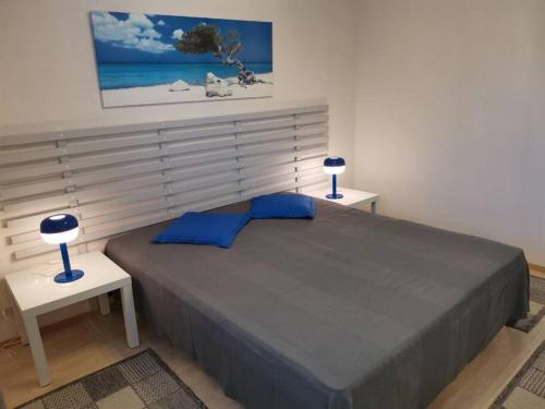 a bedroom with a large bed with two lamps on tables at Sea Apart Velhontie in Kotka