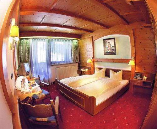 a bedroom with a large bed in a wooden room at Landhotel Zenzerwirt in Hippach