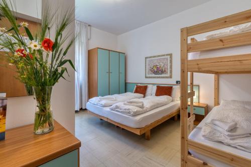 a bedroom with two bunk beds and a vase with flowers at Hotel Martinelli in Ronzo Chienis