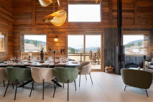 Chalet Mayen, luxueux et intimiste في Ban-sur-Meurthe-Clefcy: غرفة طعام مع طاولة وكراسي كبيرة