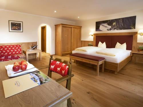 a hotel room with a bed and a table at Landhotel Zenzerwirt in Hippach