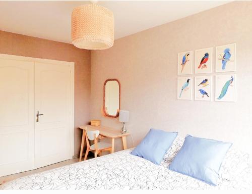 een slaapkamer met een bed, een tafel en een spiegel bij F2 Lumineux avec vue- Puy-de-Dôme à 10 min - Parking gratuit in Royat