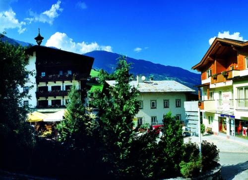 a group of buildings with mountains in the background at Landhotel Zenzerwirt in Hippach