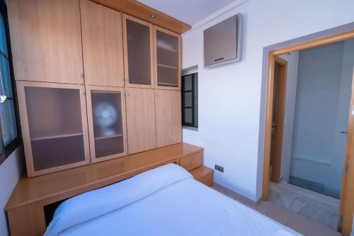 1 dormitorio con 1 cama y armario de madera en Apartamento junto a las Setas de Sevilla en Sevilla