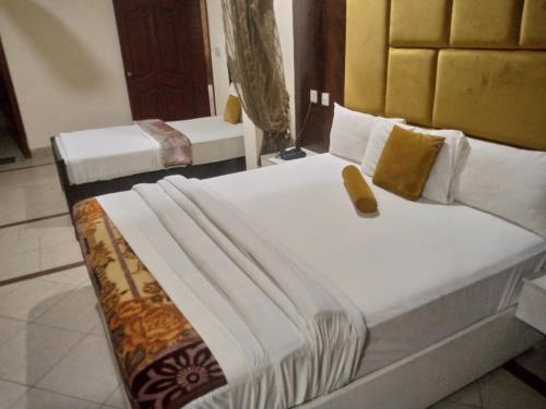 two beds in a hotel room with two at Hotel PAK Continental Multan in Multan