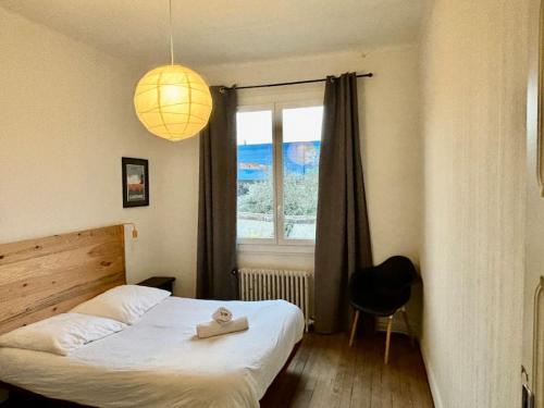 Schlafzimmer mit einem Bett und einem Fenster in der Unterkunft La grande maison-Toulouse Garonne-parking/jardin in Toulouse