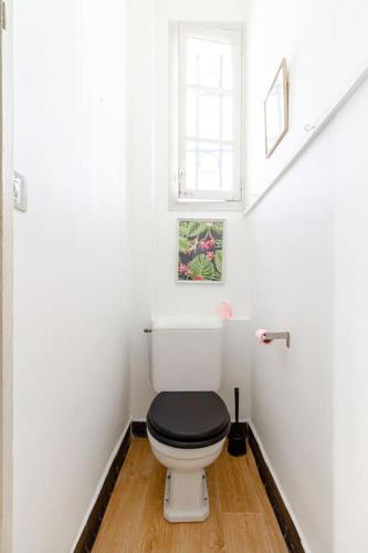 - une salle de bains blanche avec toilettes et siège noir dans l'établissement La grande maison-Toulouse Garonne-parking/jardin, à Toulouse