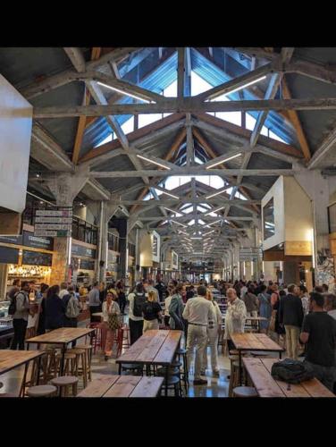 un groupe de personnes debout dans une pièce avec des tables dans l'établissement La grande maison-Toulouse Garonne-parking/jardin, à Toulouse
