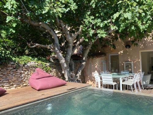 una piscina con mesa, sillas y un árbol en La Maison Jaune, une expérience inoubliable, en Villes-sur-Auzon