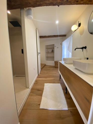 une salle de bain avec deux lavabos et un grand miroir dans l'établissement La Maison Jaune, une expérience inoubliable, à Villes-sur-Auzon