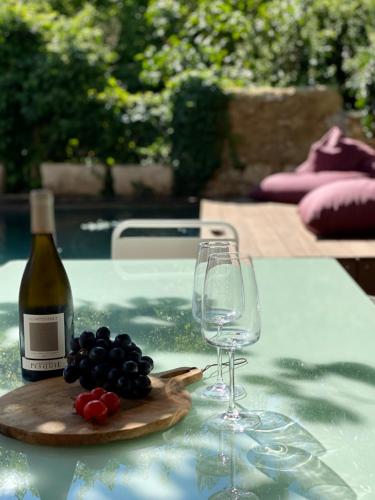 - une table avec une bouteille de vin et deux verres dans l'établissement La Maison Jaune, une expérience inoubliable, à Villes-sur-Auzon