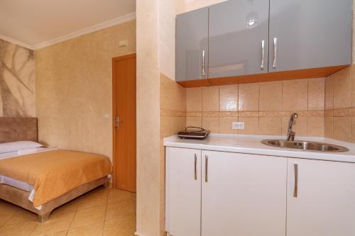 a small kitchen with a sink and a bed at Ani Lux in Dobra Voda
