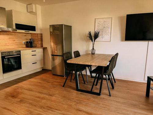 a kitchen with a table and chairs and a refrigerator at gemütliche Wohnung am Müllerring in Leipzig
