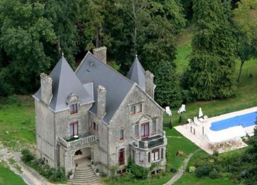 an old house with a swimming pool in front of it at Gite La Renardière in Langoëlan
