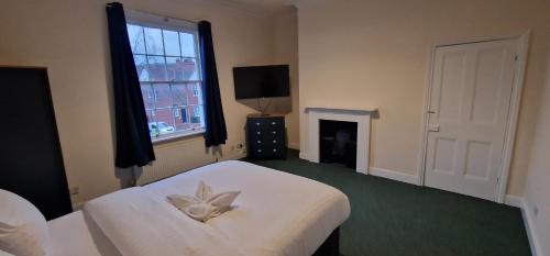 a bedroom with a white bed with a flower on it at ROOMS in WAKEFIELD CITY CENTRE in Wakefield