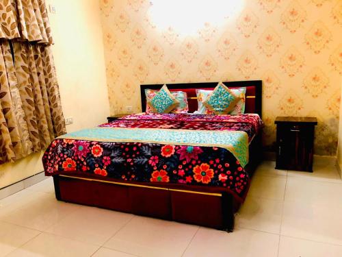 a bedroom with a bed with a floral bedspread at 2BHK Independent Service Apart with Lift in Vasant Kunj New Delhi in New Delhi