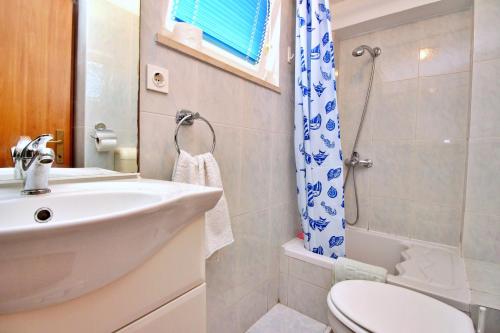 a bathroom with a sink and a toilet and a shower at Apartment Beakovic in Šilo