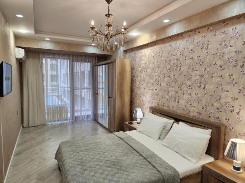 Park Azure Lux apartment في باكو: غرفة نوم بسرير وجدار زهري