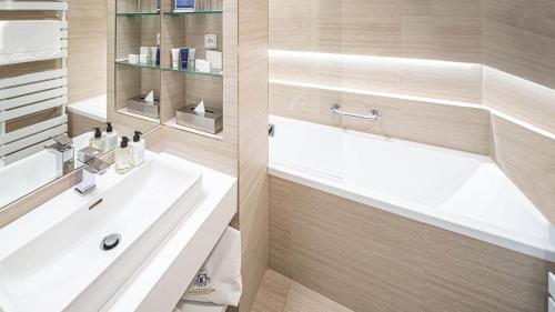 a bathroom with a sink and a bath tub at HOTEL Hraniční zámeček in Hlohovec