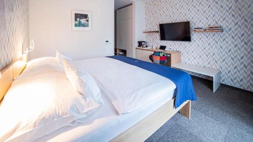 a bedroom with a large bed with a tv on the wall at HOTEL Hraniční zámeček in Hlohovec