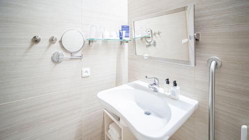 a bathroom with a sink and a mirror at HOTEL Hraniční zámeček in Hlohovec