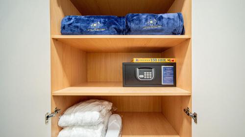 a small cabinet with a microwave in a closet at HOTEL Hraniční zámeček in Hlohovec