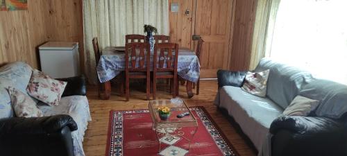 ein Wohnzimmer mit einem Sofa und einem Tisch in der Unterkunft Bonita casa con vista al mar Las Cruces El Tabo in Las Cruces