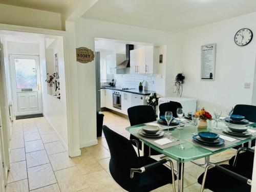 a dining room and kitchen with a table and chairs at 5 bedroom detached house sleeps 13 spacious Parking 5 mins driving to Bicester Village in Bicester