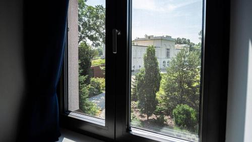 a window with a view of a building at HOTEL Hraniční zámeček in Hlohovec