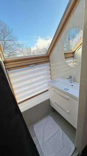 La salle de bains est pourvue d'une grande fenêtre et d'un lavabo. dans l'établissement Magnifique maison située à 14 km de la Tour Eiffel, à Igny