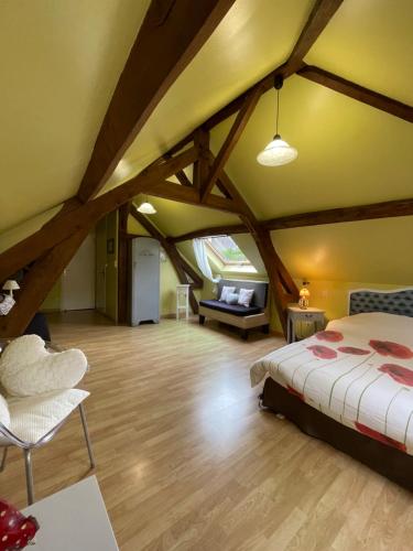 a bedroom with a bed and a couch in a room at Le Clos in Hucqueliers